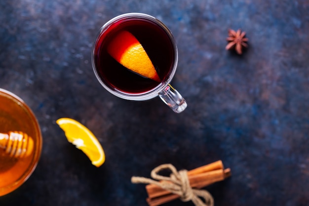 Vinho quente com laranja e especiarias em uma caneca de vidro