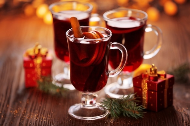 Vinho quente com presentes na mesa de madeira