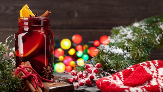 Vinho quente de Natal com especiarias e citrinos árvore de Natal e luzes bokeh