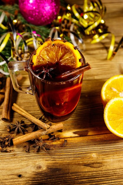 Vinho quente de Natal com especiarias e decoração de Natal na mesa de madeira