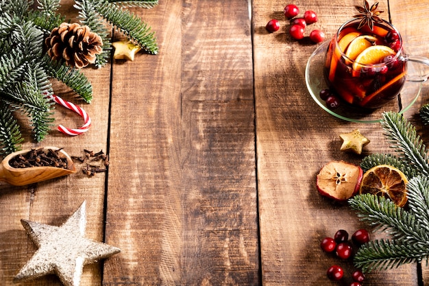 Vinho quente de Natal com especiarias em uma mesa de madeira rústica.