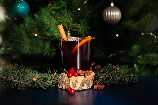 Vinho quente de Natal com pau de canela, laranja, anis e cravo-da-índia em um fundo azul. Férias de inverno.