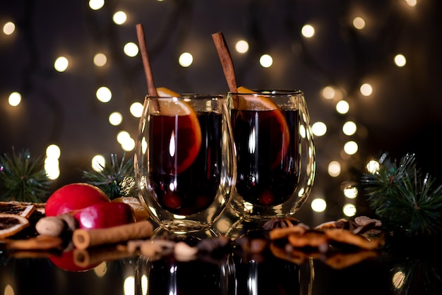 Vinho quente de Natal de vinho tinto com especiarias e frutas em um fundo preto Natal