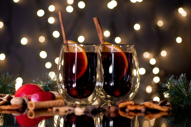 Vinho quente de Natal de vinho tinto com especiarias e frutas em um fundo preto Natal