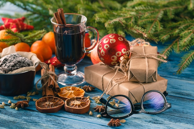 Vinho quente quente de natal com canela cardamomo e anis na mesa de madeira