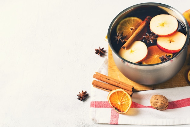 Vinho quente tradicional na panela com especiarias no fundo branco