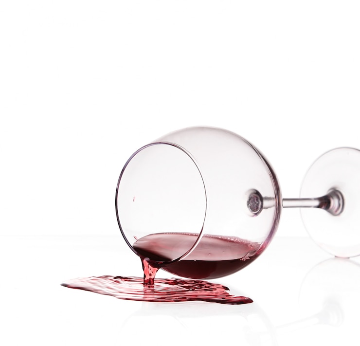 Foto vinho tinto derramado de vidro sobre fundo branco
