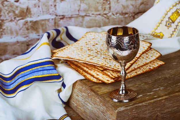 Foto vinho tinto do fundo da páscoa judaica e pão judaico do feriado do matzoh sobre a placa de madeira.