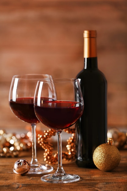 Vinho tinto e enfeites de natal na mesa de madeira com fundo de madeira