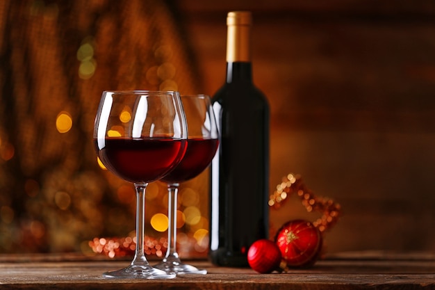 Vinho tinto e enfeites de natal na mesa de madeira com fundo de madeira