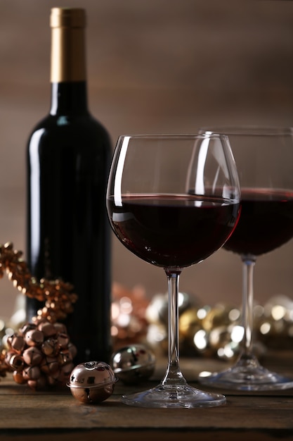 Vinho tinto e enfeites de Natal na mesa de madeira com fundo de madeira