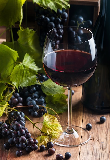 Vinho tinto e uvas em ambiente vintage em madeira