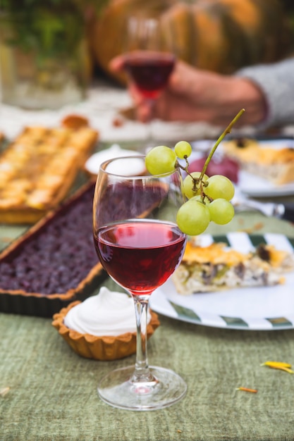 Vinho tinto em um copo em uma tabela de férias em casa no jardim.