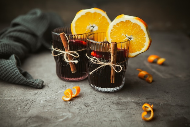 Vinho tinto quente de Natal com especiarias aromáticas e frutas cítricas em caixa de madeira, close-up. Bebida quente tradicional na época do Natal