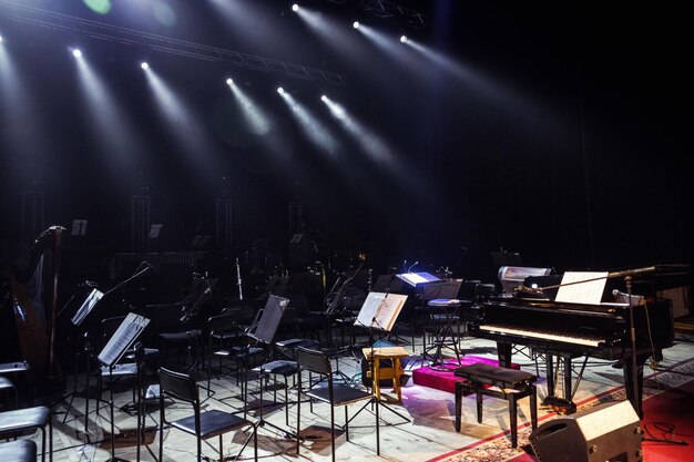 Foto vinnitsaucrania 13 de diciembre de 2015 sillas vacías y soporte de piano en el escenario en la sala de conciertos sinfónicos de escena