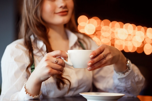 Vinnytsia Ucrania 12 de septiembre de 2022 Una niña sostiene una taza de café en sus manos en una cafetería Enfoque en sus manos