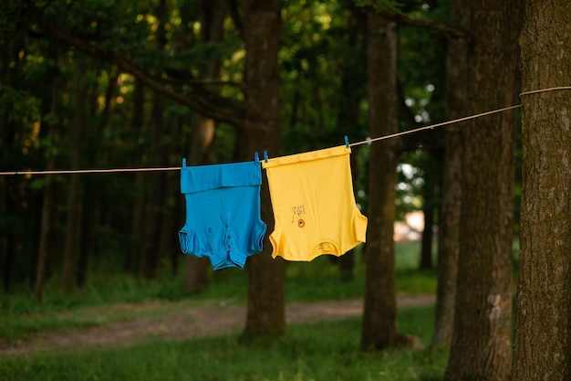 Vinnytsia Ukraine 20. August 2022 Zwei blaue und gelbe T-Shirts werden nach dem Waschen in der Natur getrocknet