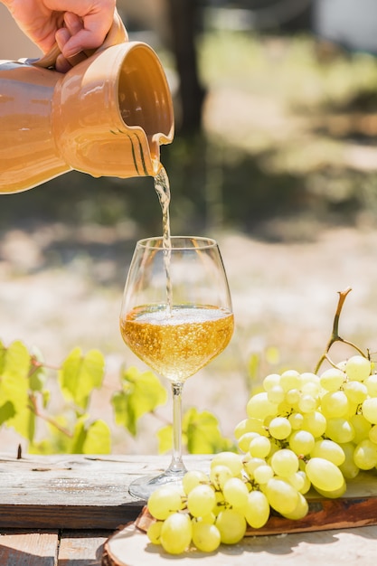 Vino ambarino en copas sobre la naturaleza: bodegón con queso, uvas y vino en un estilo rústico. Vino nacional georgiano o vino italiano passito