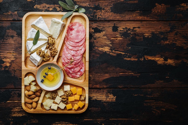 Vino aperitivos surtidos de queso sobre una tabla de madera