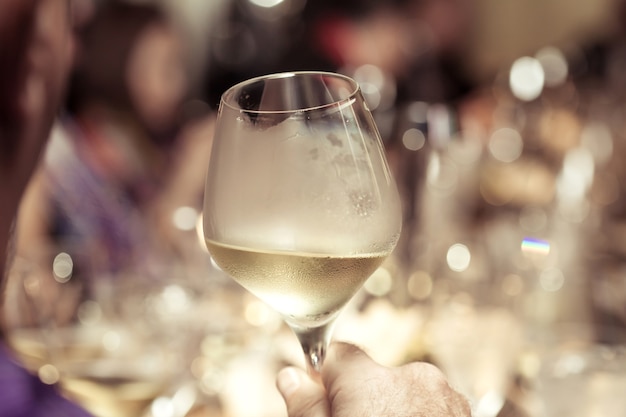 vino blanco en la mano con la cena en el restaurante