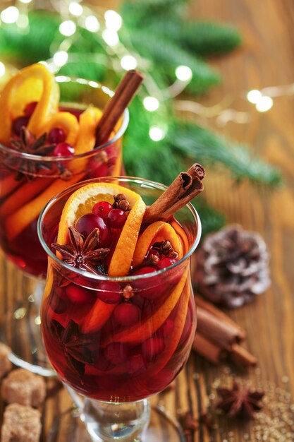 Vino caliente caliente de Navidad Copas de vino caliente con especias aromáticas canela anís azúcar y ramas de abeto con bokeh y decoraciones Bebida festiva tradicional de Navidad Bebida navideña de invierno