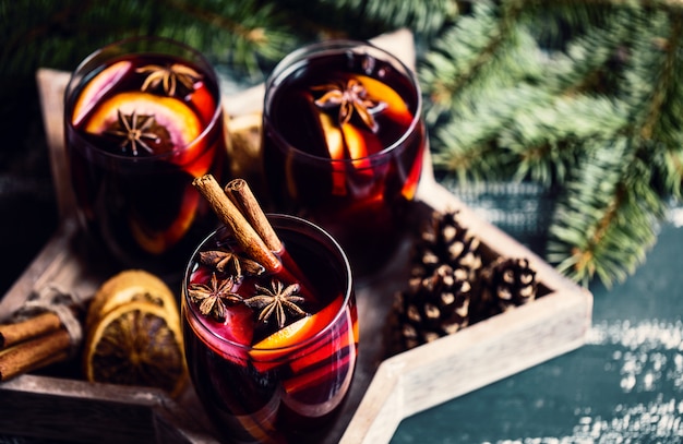 Vino caliente caliente de Navidad en un vaso con especias y cítricos. Vino caliente con canela, anís y naranja.