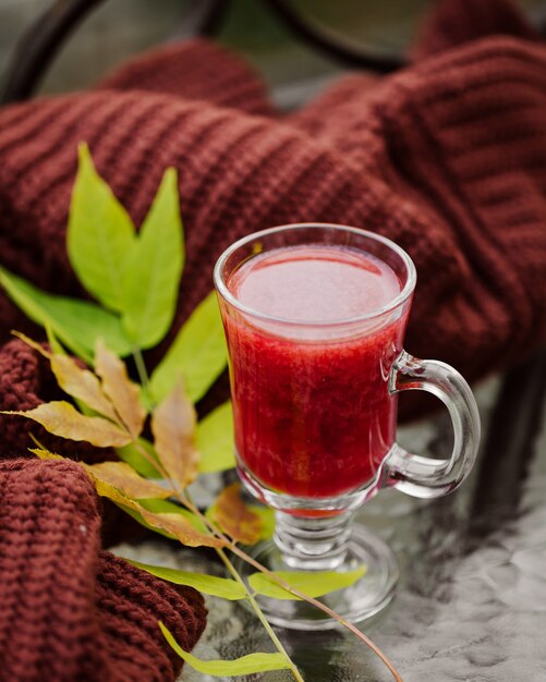 Vino caliente en copa con jersey calentito. Bebida tradicional de otoño