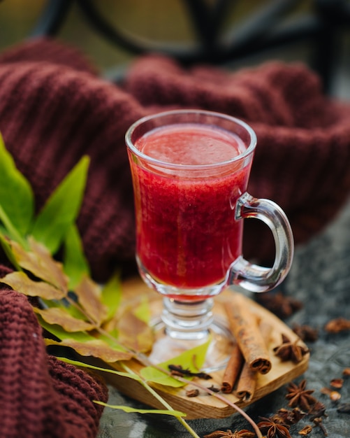 Vino caliente en copa con jersey calentito. Bebida tradicional de otoño