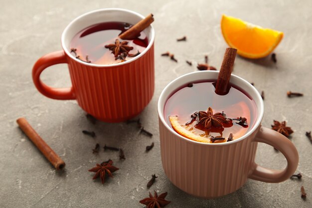 Vino caliente con estrellas de canela y anís sobre fondo gris. Día de Gracias.