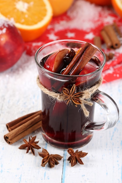 Vino caliente fragante en vidrio en primer plano de la nieve