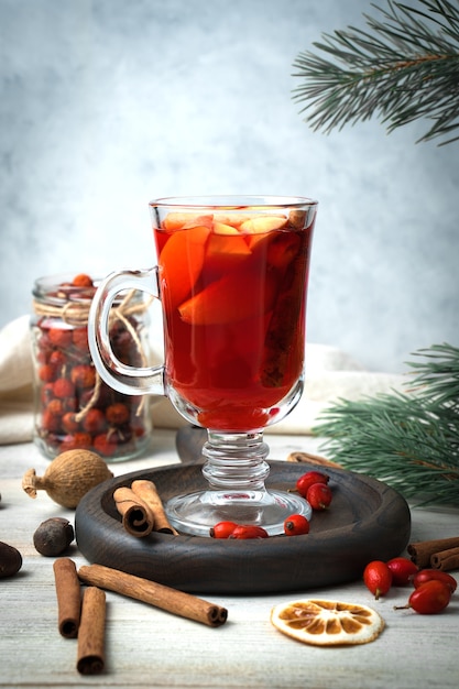 Vino caliente con frutas, canela y frutos rojos a la luz.