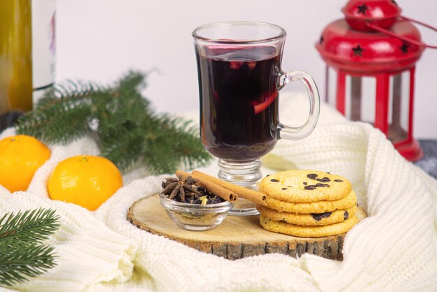 Vino caliente con mandarinas y galletas closeup en un acogedor interior navideño