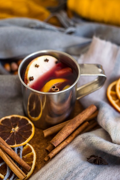 Vino caliente con manzana, naranja, clavo de olor, canela y anís en una taza de metal