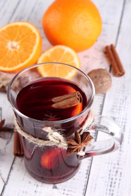 Vino caliente con naranjas y especias sobre fondo de madera