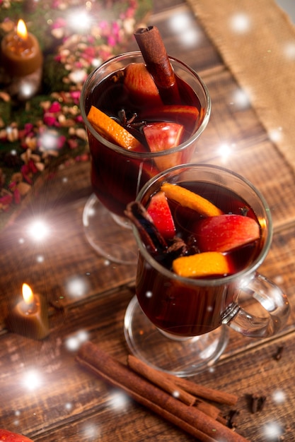 Vino caliente de Navidad con frutas y especias en mesa de madera