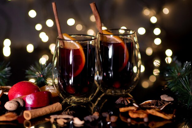 Vino caliente de Navidad de vino tinto con especias y frutas sobre un fondo negro Navidad