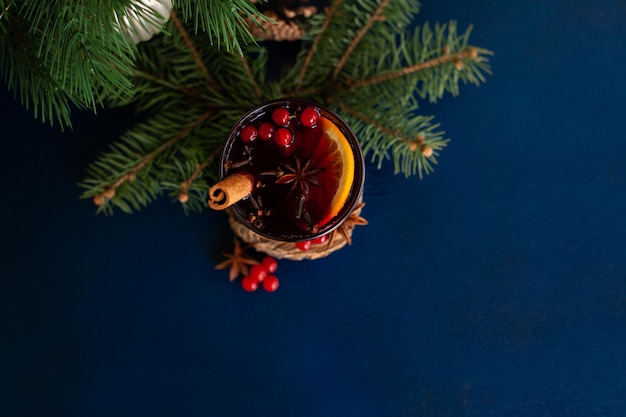 Foto vino caliente navideño con canela, naranja, anís y clavo sobre un fondo azul. vacaciones de invierno.