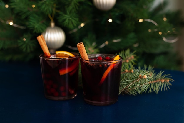 Foto vino caliente navideño con canela, naranja, anís y clavo sobre un fondo azul. vacaciones de invierno.