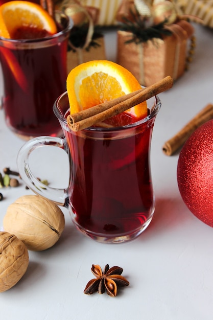 Vino caliente con rodajas de naranja, canela en rama con bolas navideñas