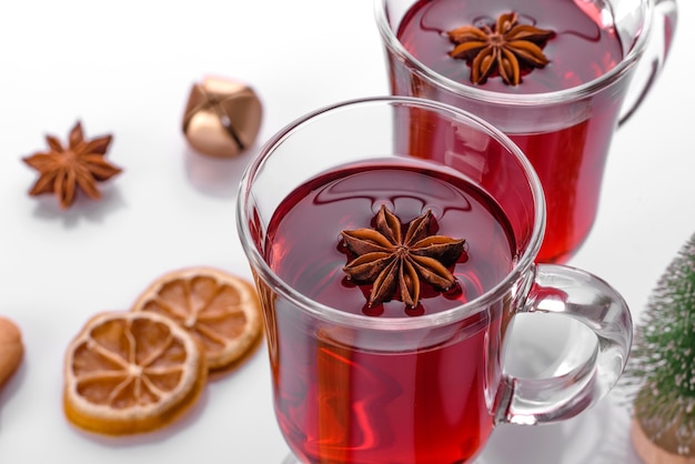 Vino caliente rojo caliente aislado sobre fondo blanco con especias navideñas