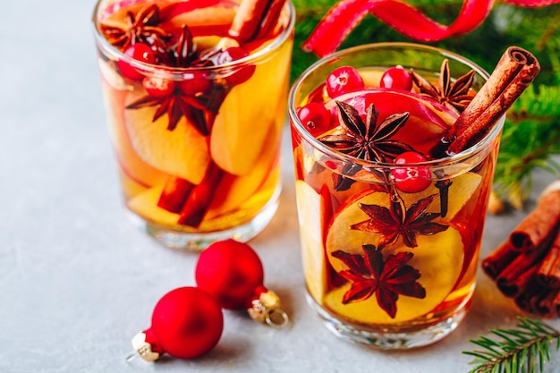 Vino caliente con sidra de manzana o ponche navideño en vaso con frutas y especias