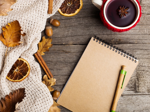 Vino caliente en una taza en un estuche y un cuaderno