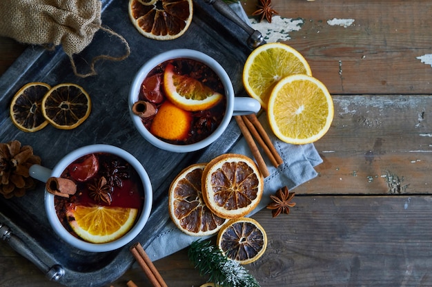 Vino caliente en tazas de metall gris con naranja y especias Estilo rústico