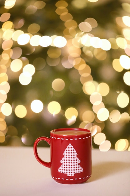 Vino caliente, té navideño en una taza roja con un árbol de navidad