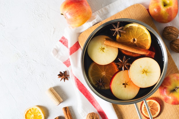 Vino caliente tradicional en una olla con especias en blanco