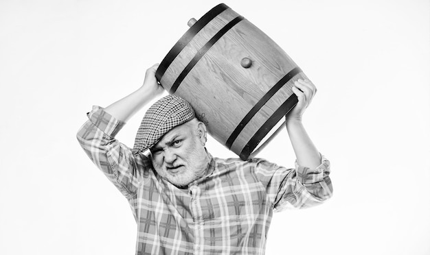 Vino casero Concepto de bodega Hombre barbudo senior llevar barril de madera para vino fondo blanco Producir vino tradición familiar Producto de fermentación Vino natural hecho de uvas orgánicas