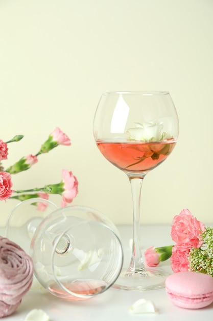 Foto vino, dulces y flores en la mesa blanca