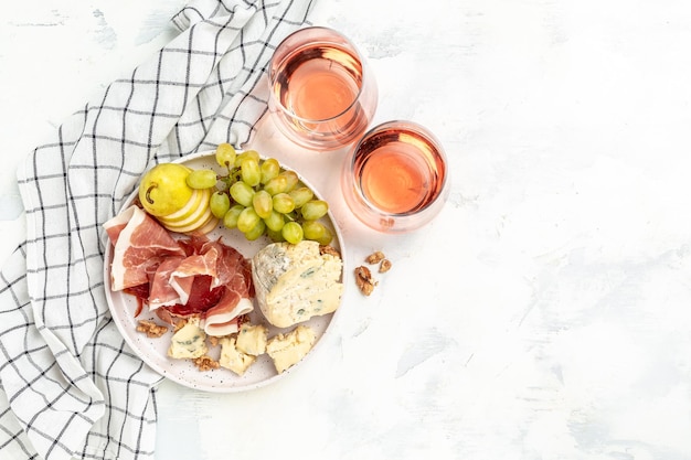 Vino y queso bodegón vino y quesos variados Plato con fruta Uvas Pera Nueces Anacardos Queso con moho Gorgonzola Copa de vino con queso