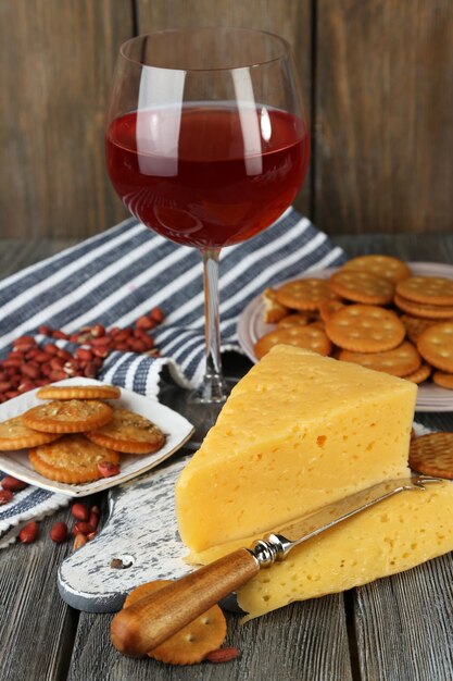 Vino, queso y galletas en primer plano de la mesa de madera