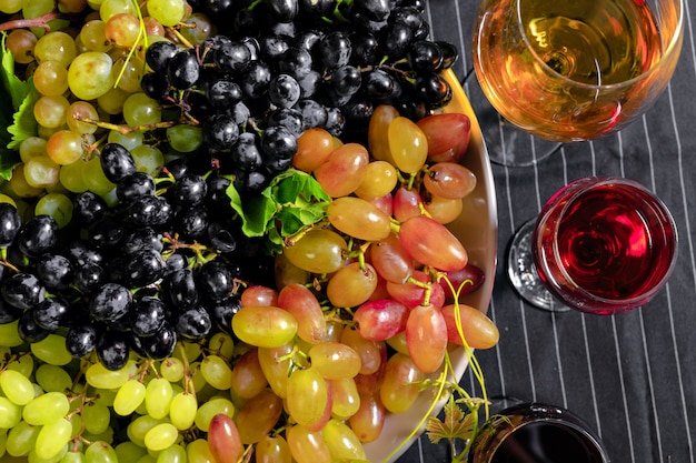 Vino con ramas de uvas blancas. Sobre una mesa de madera.